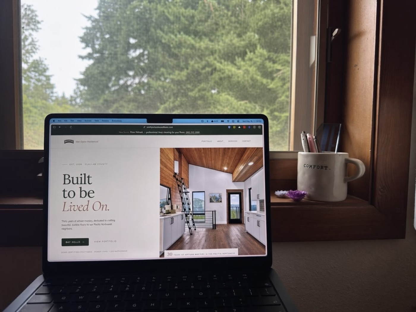 Karen's laptop by a window, showing a client site she built